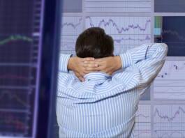 Mężczyzna obserwuje wykresy i ocenia ryzyko inwestowania w papiery wartościowe